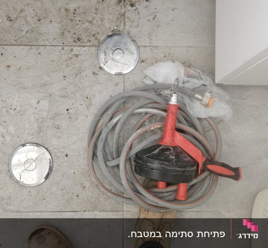 כלי עבודה של אינסטלטור על רצפה מלוכלכת